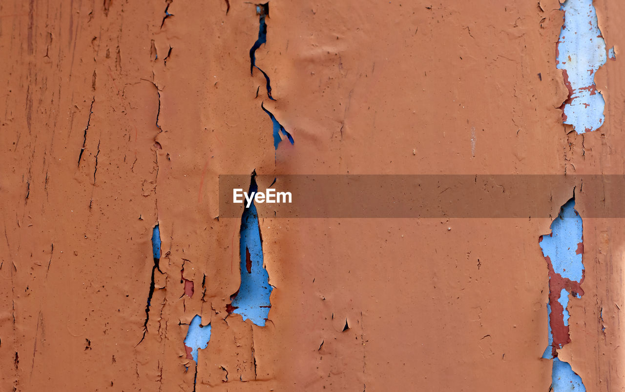 Paint that is cracked on the wall,red rust primer,