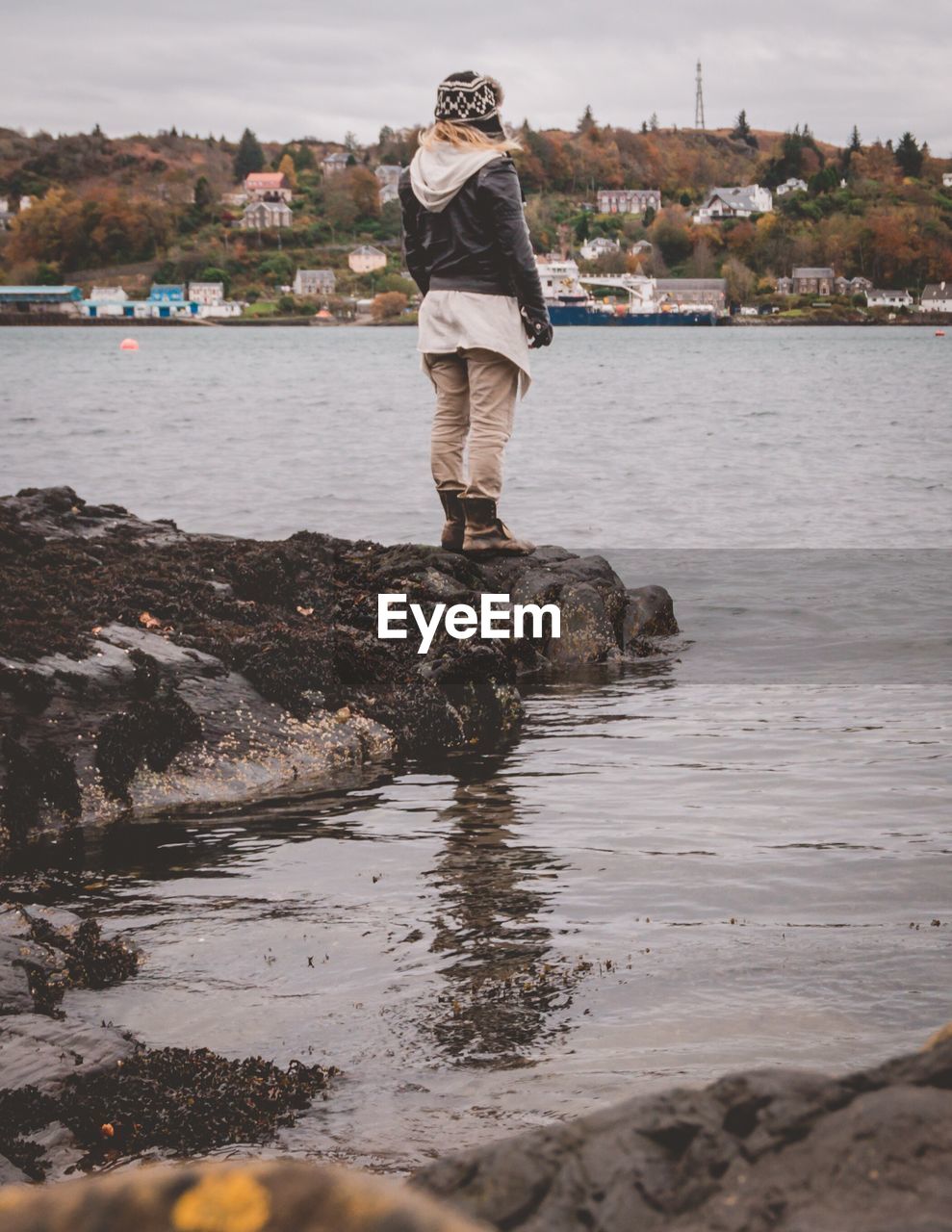 Rear view of woman standing on rocks