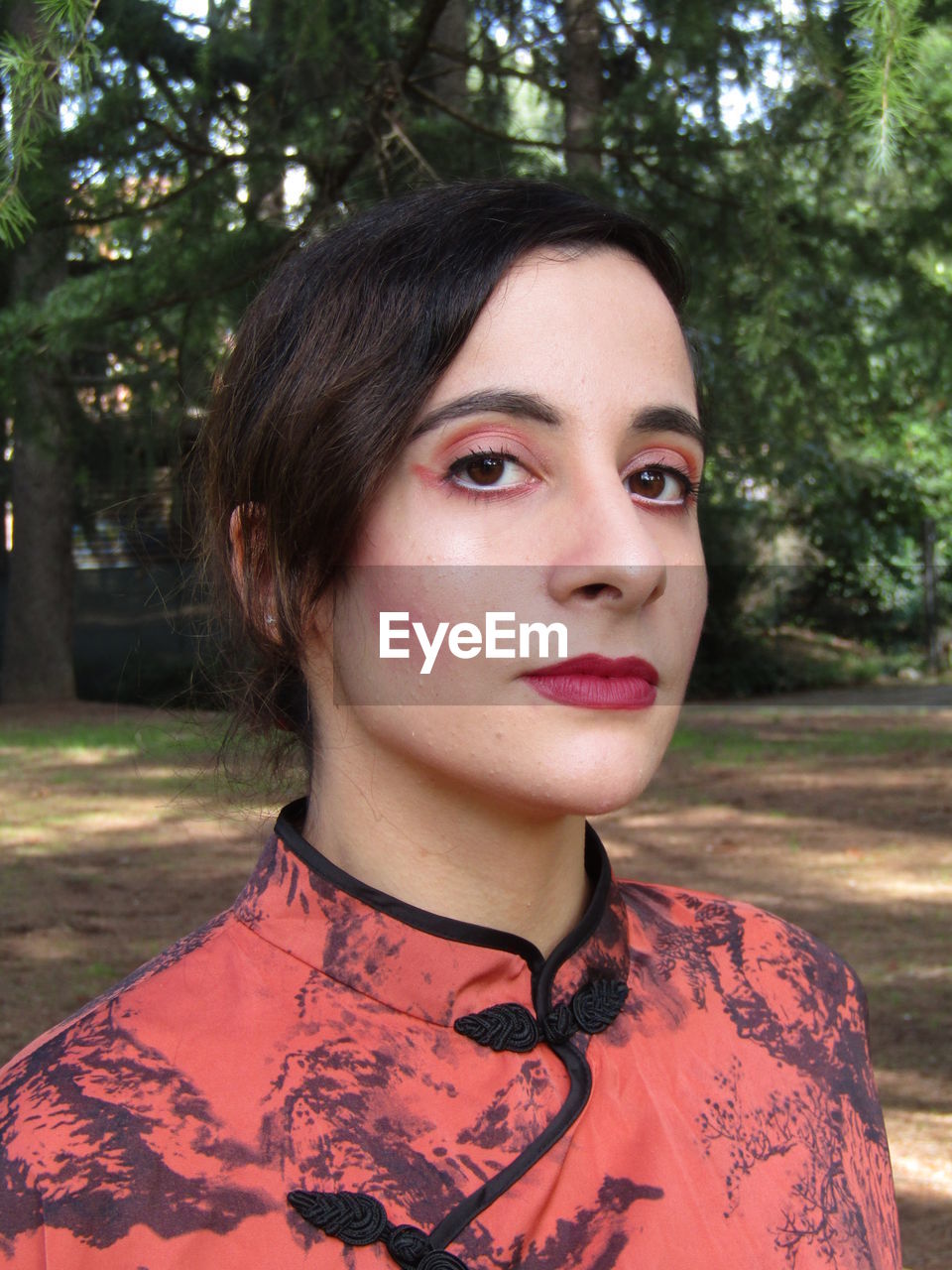 CLOSE-UP PORTRAIT OF YOUNG WOMAN AGAINST TREE