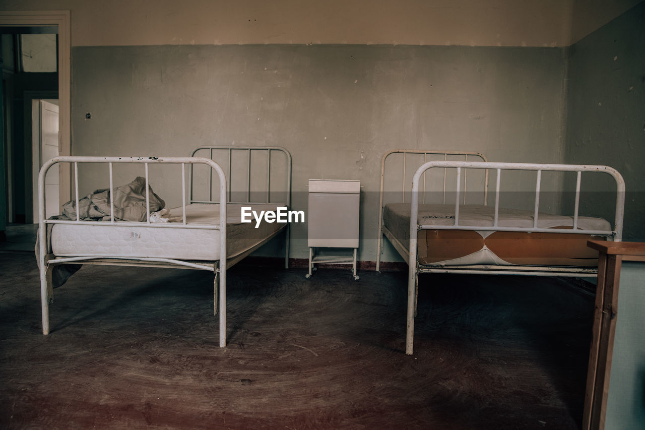 EMPTY CHAIRS AND TABLE AGAINST WALL IN ROOM