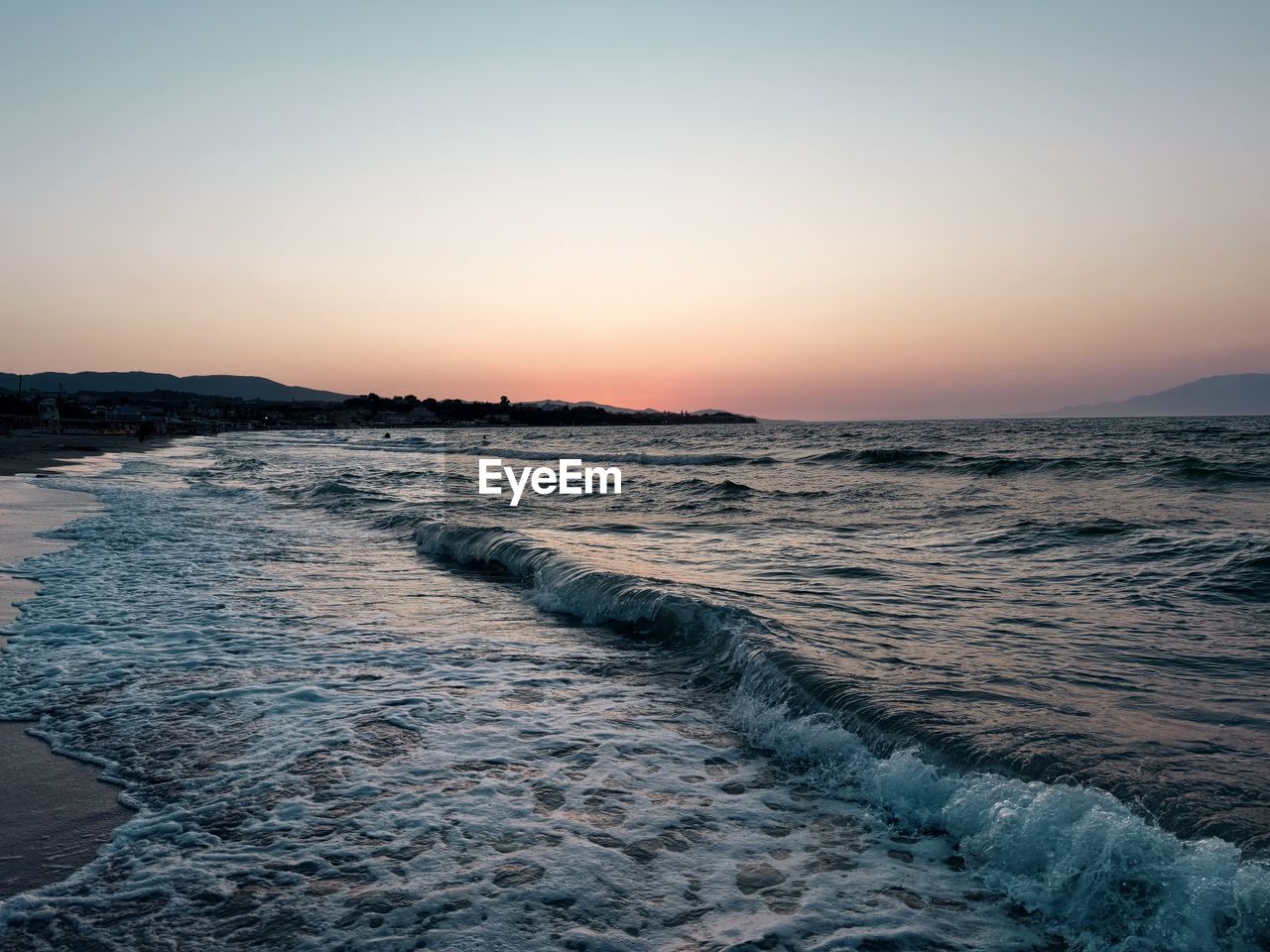 sky, sea, sunset, water, ocean, wave, scenics - nature, beauty in nature, wind wave, land, shore, horizon, nature, coast, beach, motion, environment, dawn, tranquility, body of water, clear sky, no people, tranquil scene, horizon over water, landscape, sun, outdoors, seascape, idyllic, travel destinations, evening, sports, travel, water sports, cloud, sand, blue, non-urban scene, twilight, sunlight, orange color