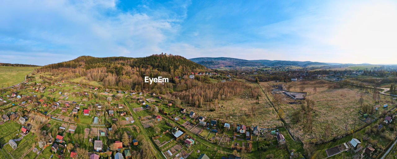 Mountain village among green fields, aerial view.