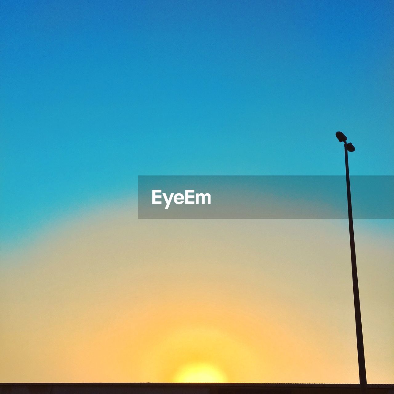 Low angle view of silhouette street light against clear sky during sunset