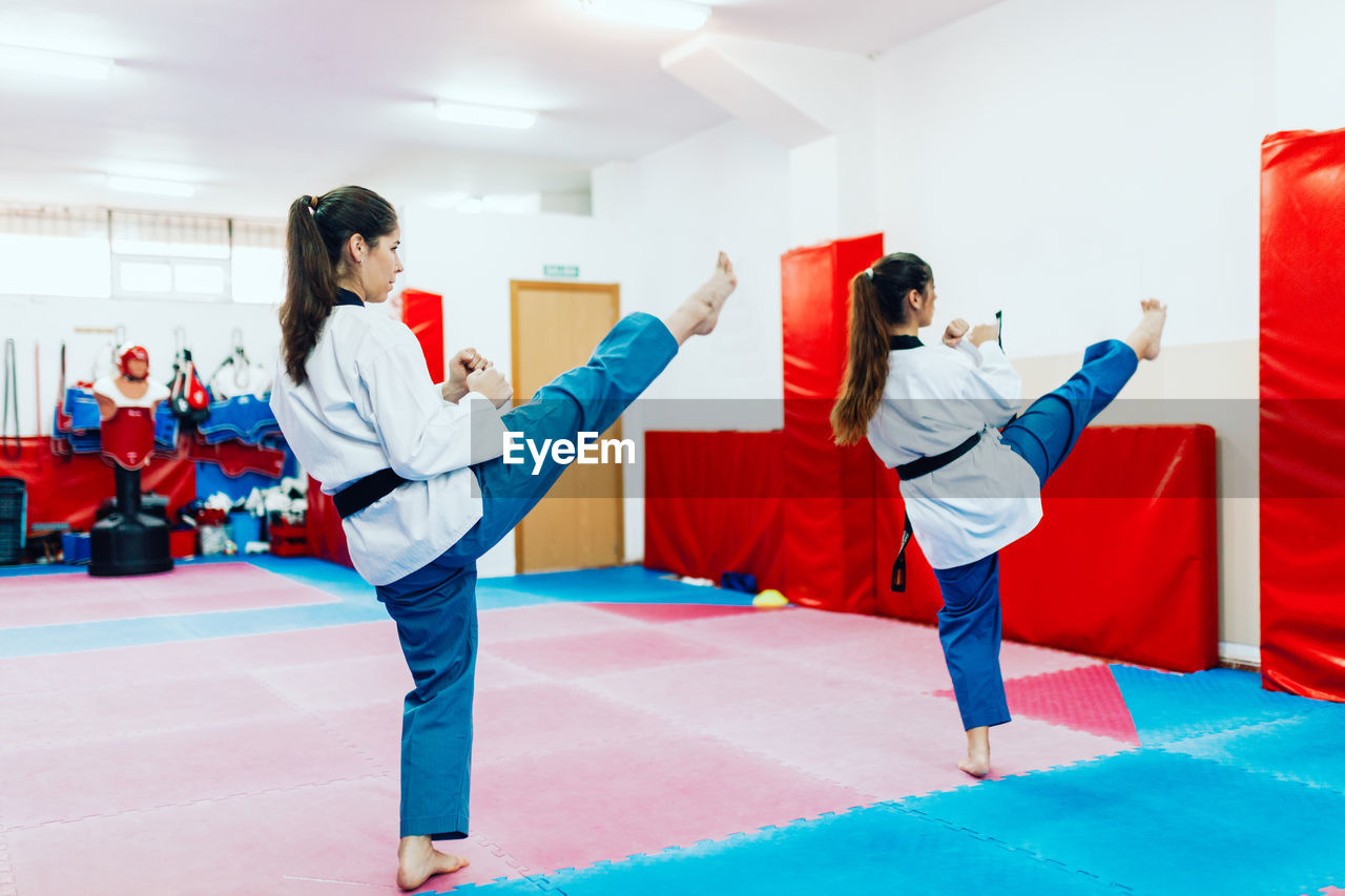 Rear view of people doing taekwondo