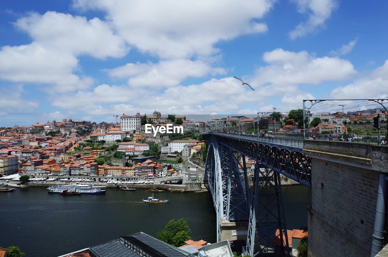 Bridge over river in city against sky