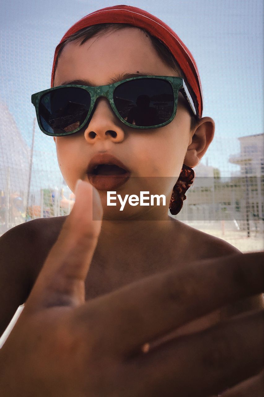 CLOSE-UP PORTRAIT OF A BOY WEARING SUNGLASSES