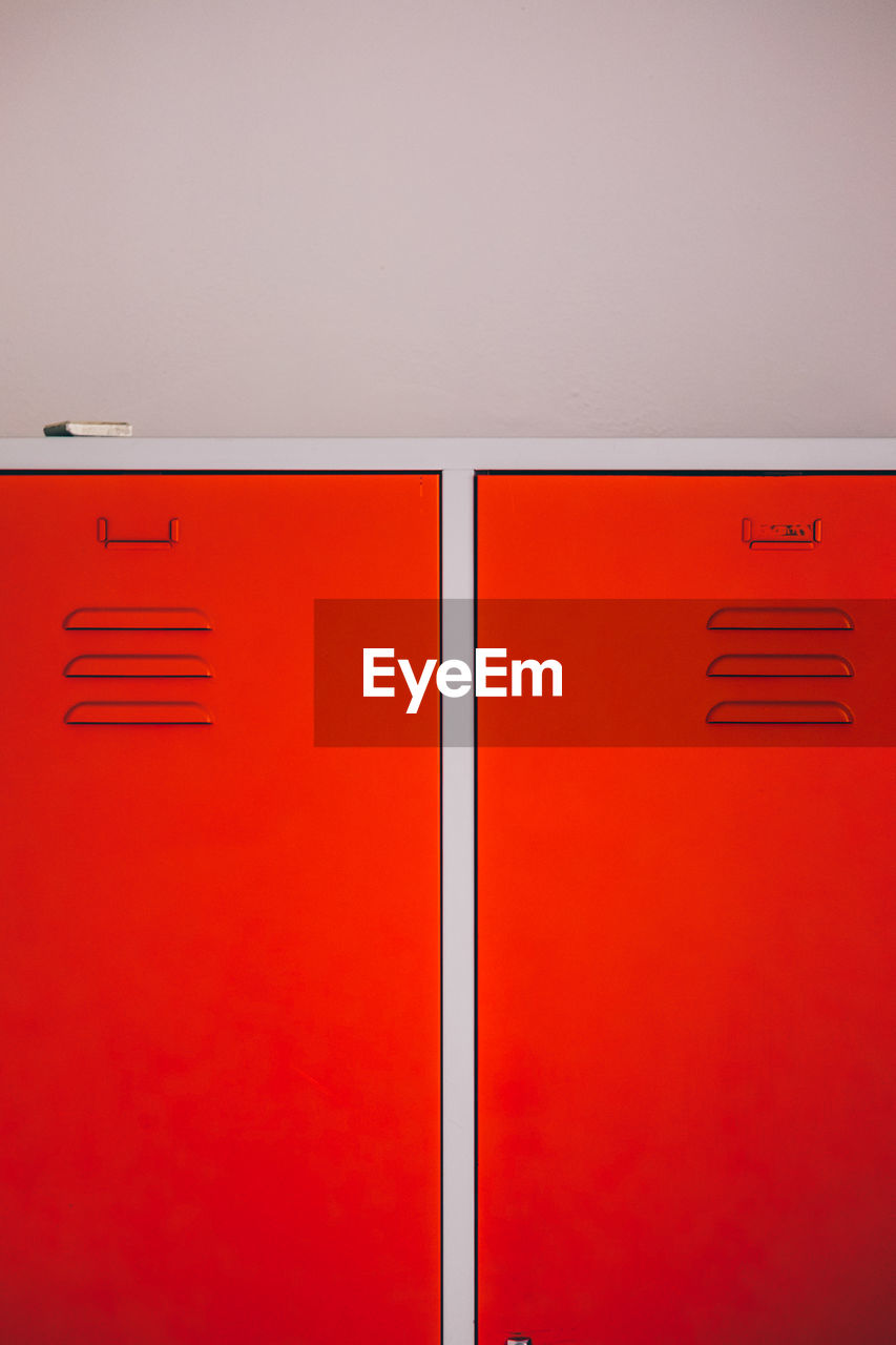 Close-up of red lockers by wall