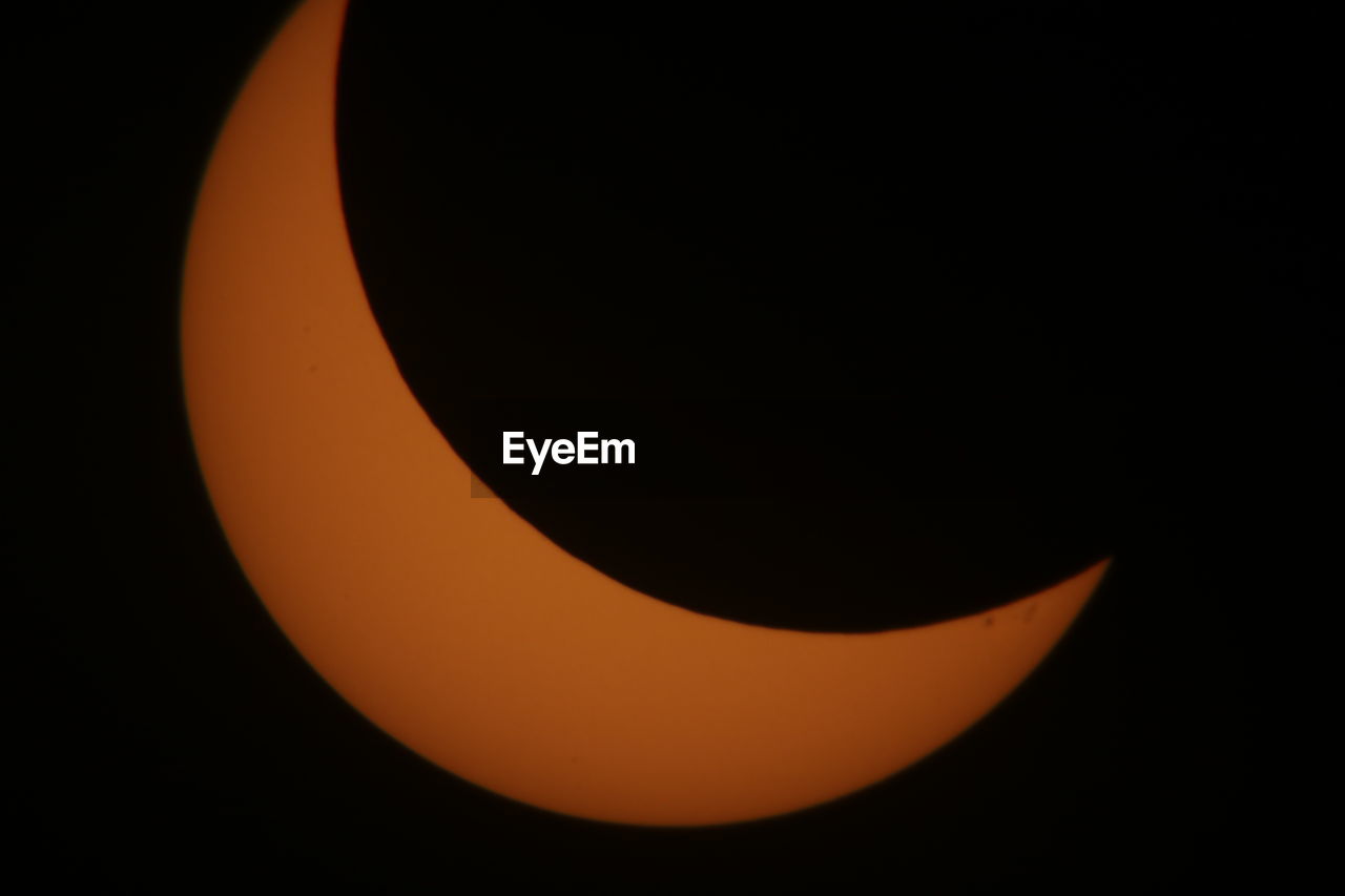 CLOSE-UP OF ILLUMINATED ORANGE AGAINST SKY AT NIGHT