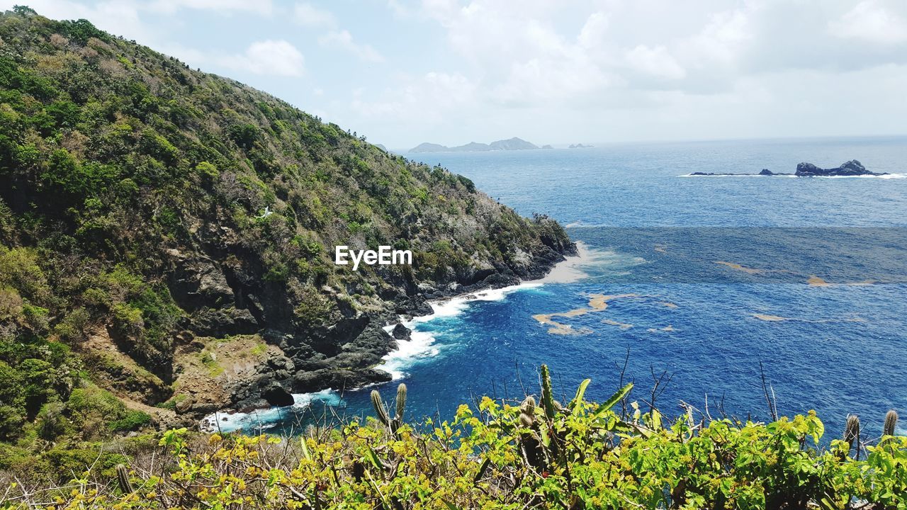 SCENIC VIEW OF SEA BY MOUNTAINS AGAINST SKY