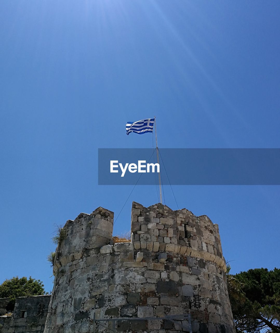 sky, architecture, blue, nature, history, low angle view, flag, the past, built structure, clear sky, tower, no people, day, landmark, travel, travel destinations, outdoors, patriotism, sunny, building exterior, sea, sunlight