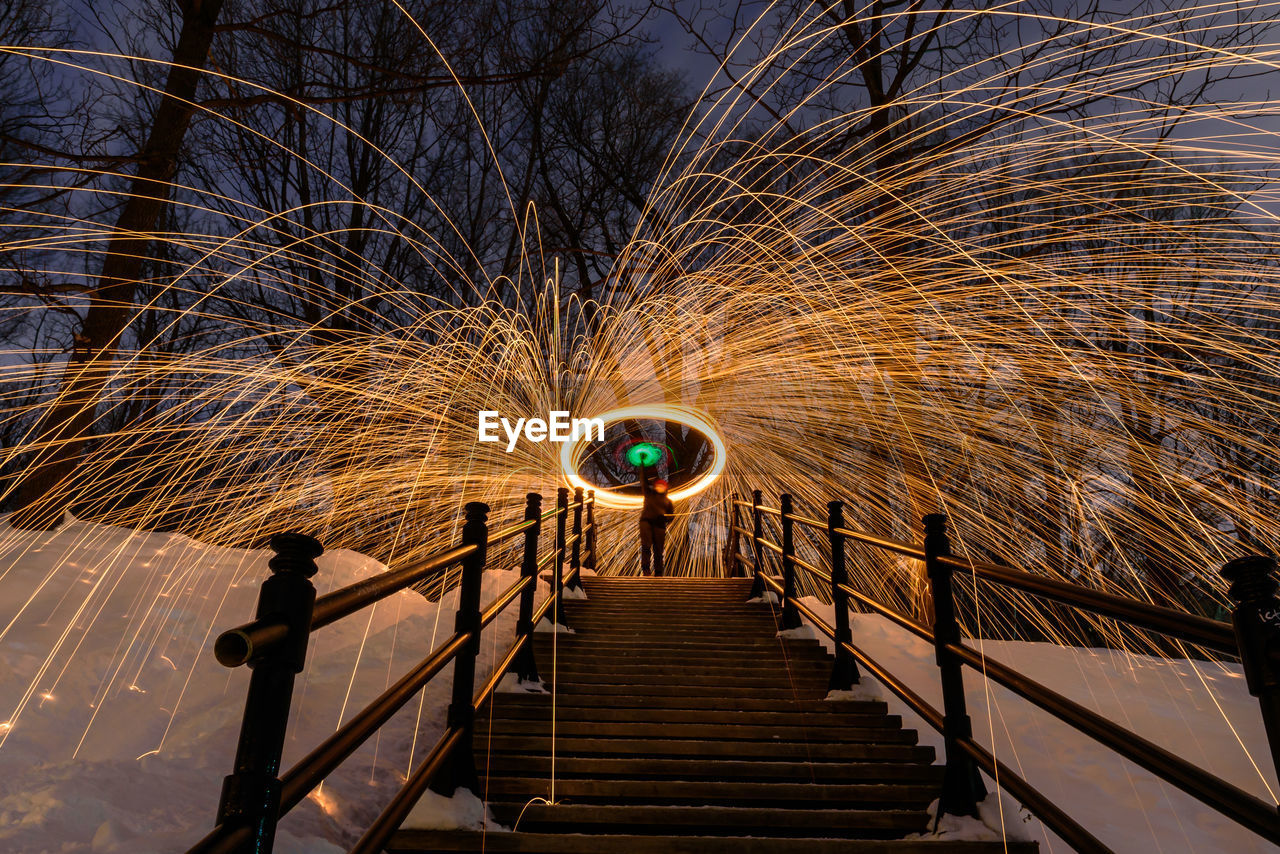 Low angle view of woman spinning wire wool while standing on steps