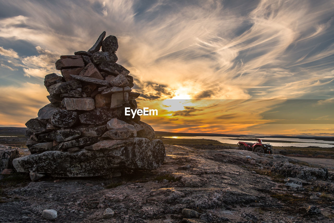 Stack of rocks against sky during sunset