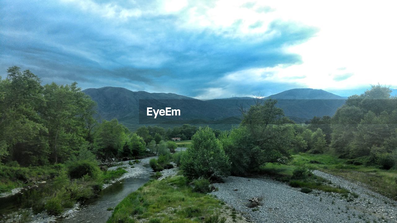 Countryside landscape against cloudy sky