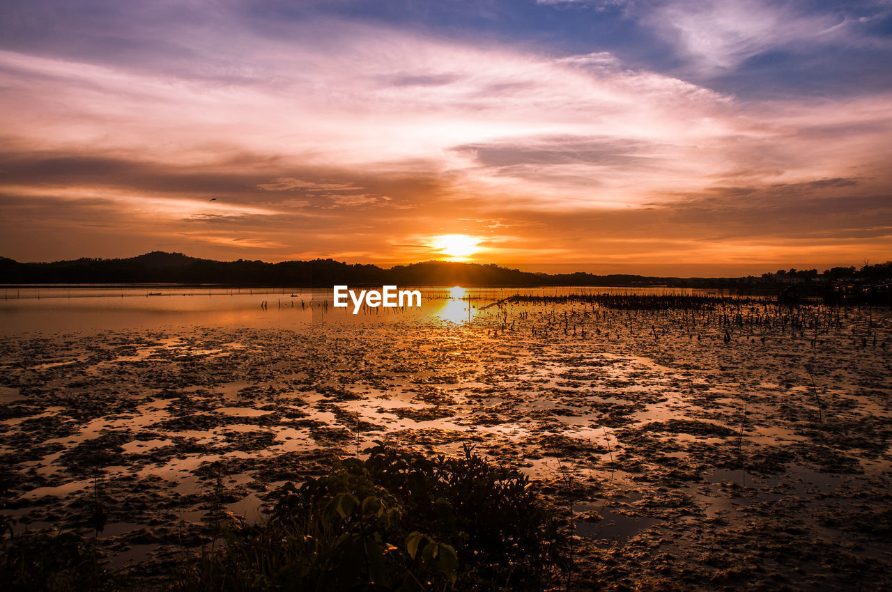 Scenic view of lake against sky during sunset