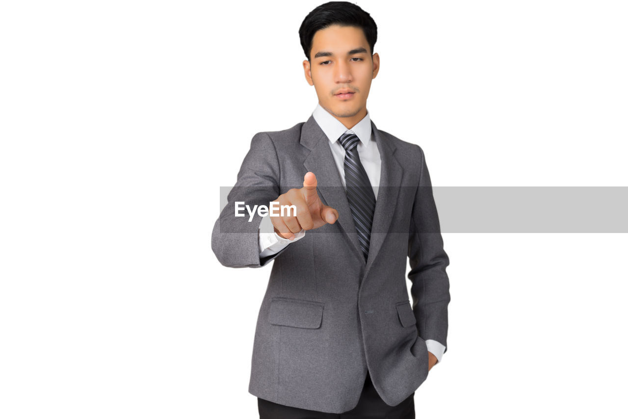 Young businessman standing against white background