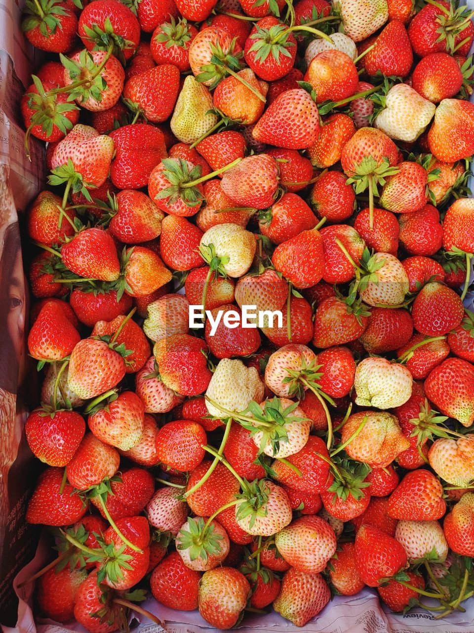 Fresh ripe juice strawberries in wood box over dark wooden background. top view