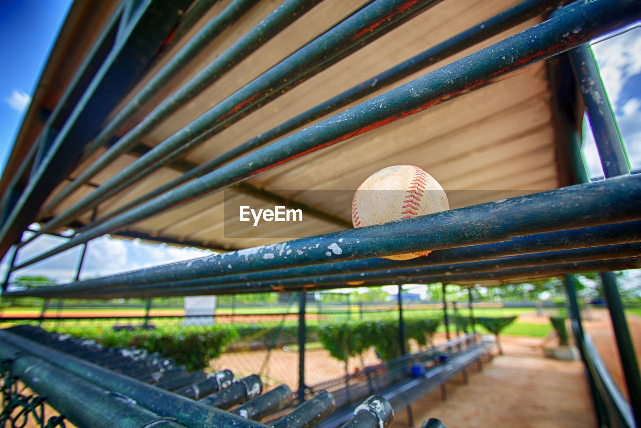 Low angle view of baseball ball on railing