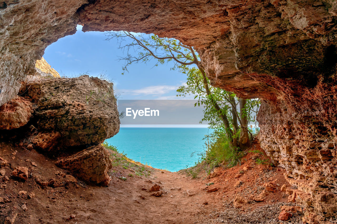 SCENIC VIEW OF ROCK FORMATIONS ON SEA AGAINST SKY