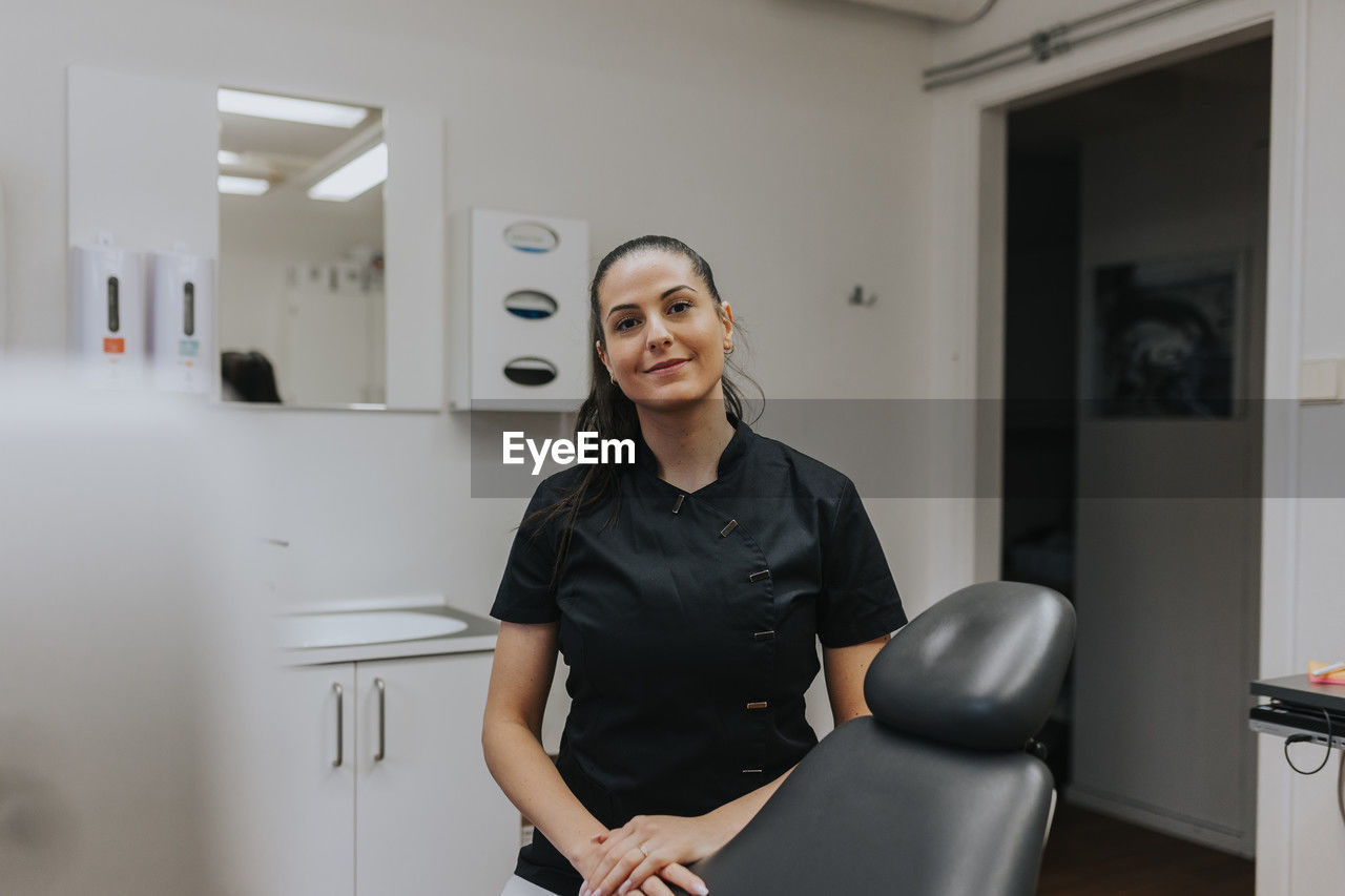 Female dentist standing in office