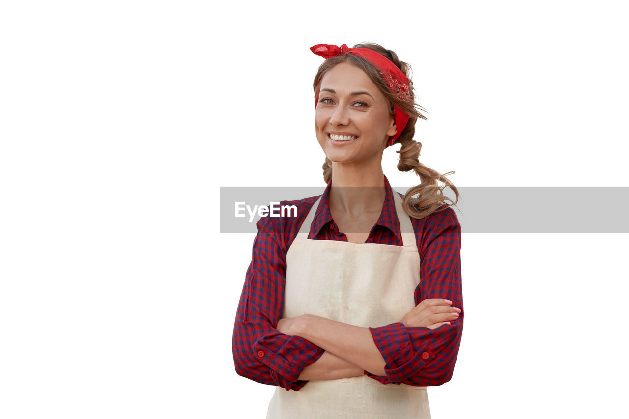 PORTRAIT OF SMILING YOUNG WOMAN AGAINST WHITE BACKGROUND