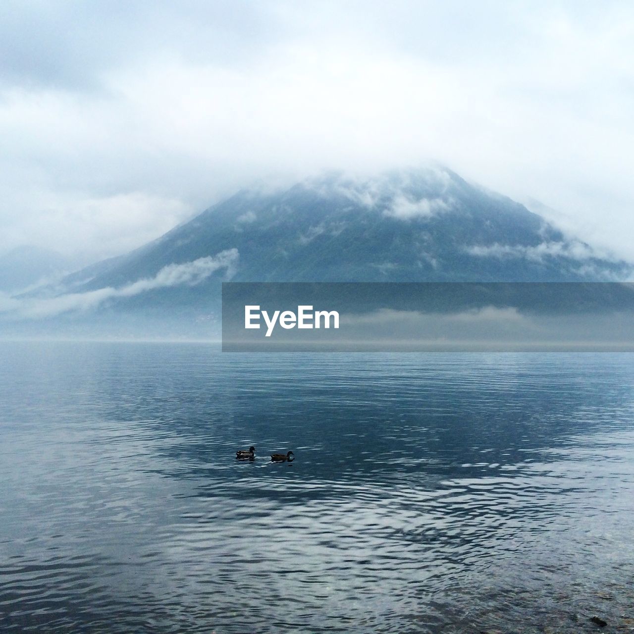 SCENIC VIEW OF SEA WITH MOUNTAIN RANGE IN BACKGROUND