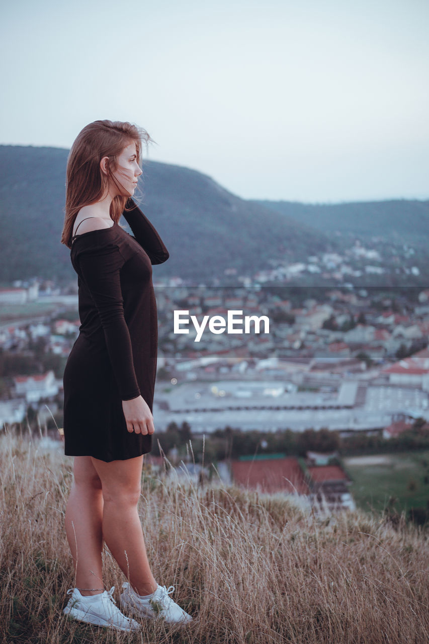 Full length of woman standing on field against sky