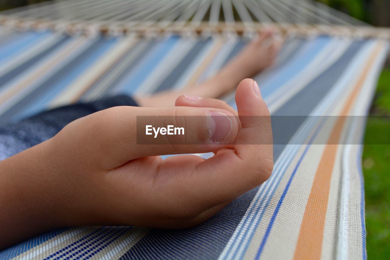 Low section of boy relaxing on hammock