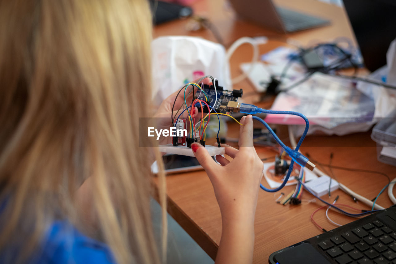 Close-up of woman repairing computer part at table