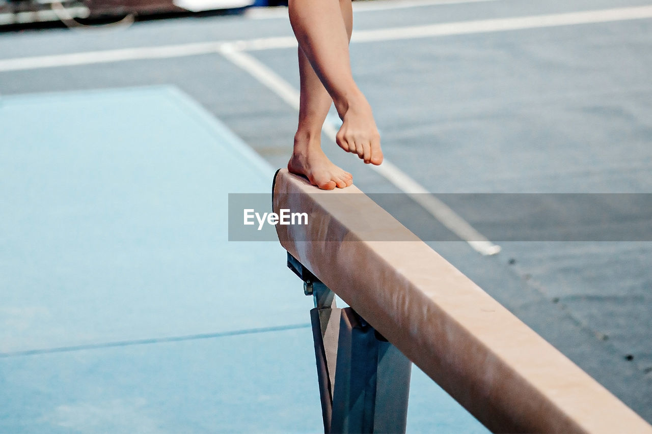 low section of woman walking on railing