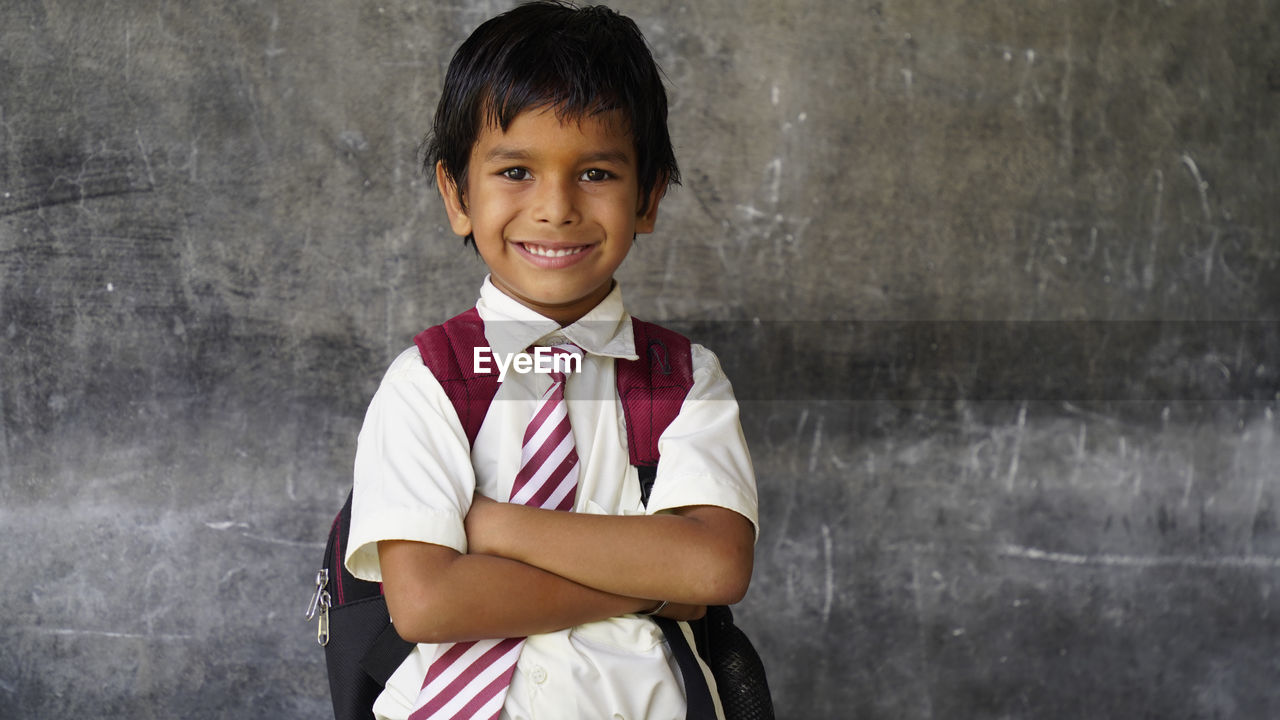 Smiling indian rural school boy with backpack looking at camera. cheerful kid wearing school uniform