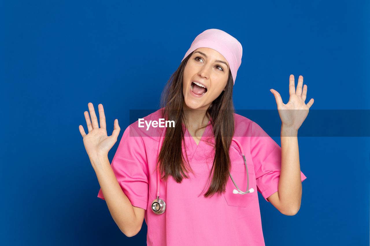 PORTRAIT OF A YOUNG WOMAN AGAINST PINK BACKGROUND