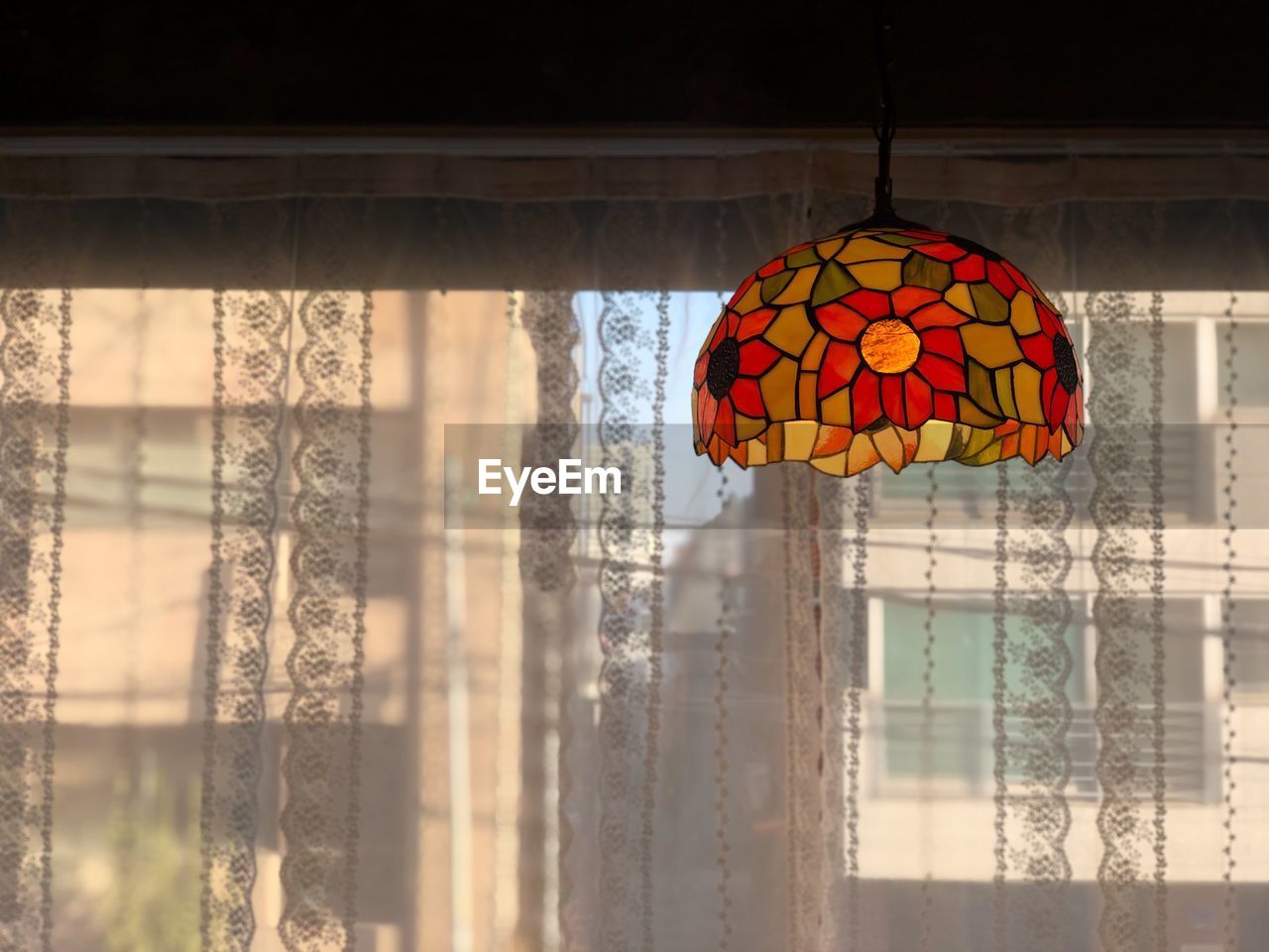 CLOSE-UP OF LANTERNS HANGING ON WINDOW