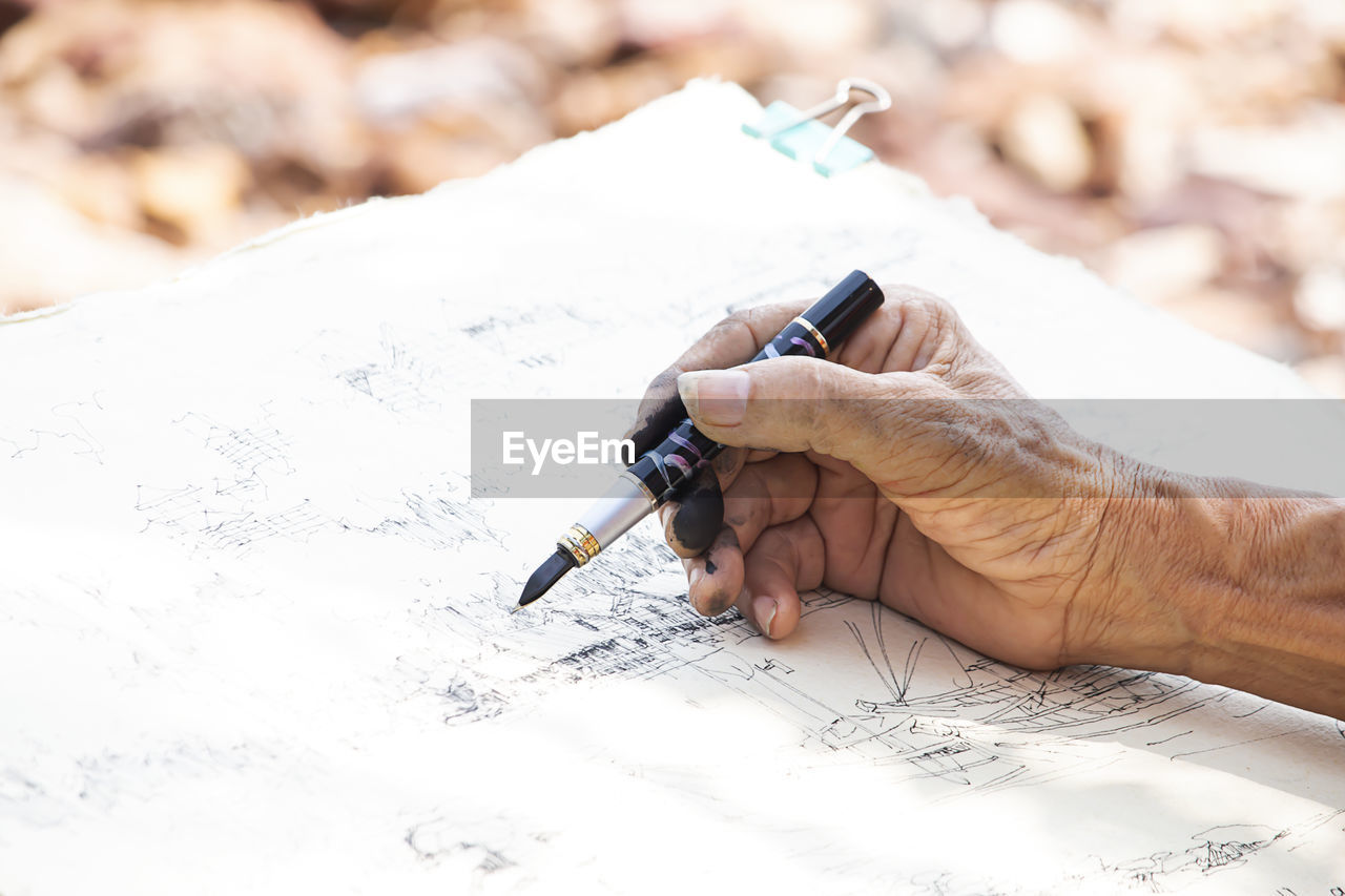 Close-up of man working on paper