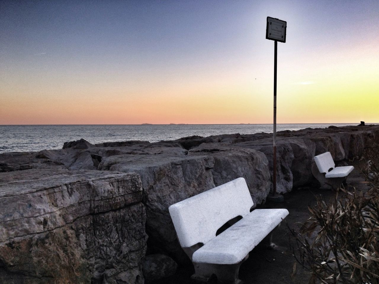 Benches by sea at sunset