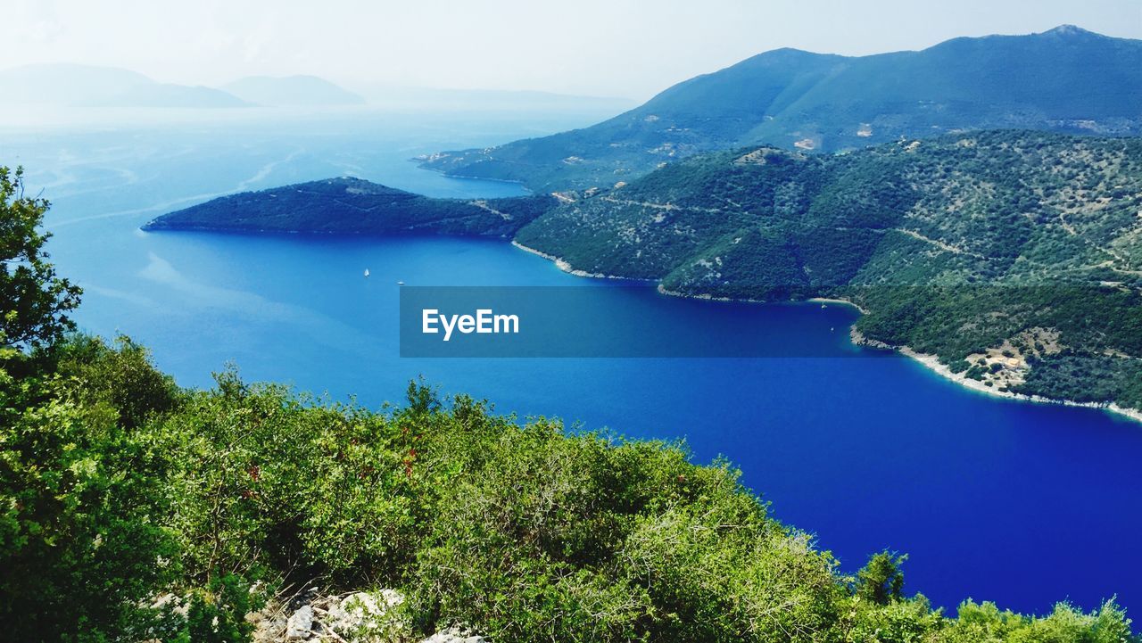 High angle view of sea and mountains against sky