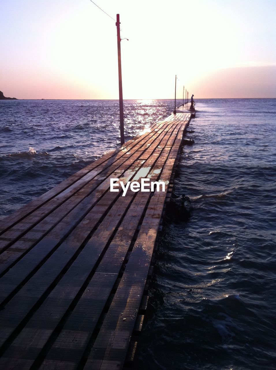 Pier on sea at sunset