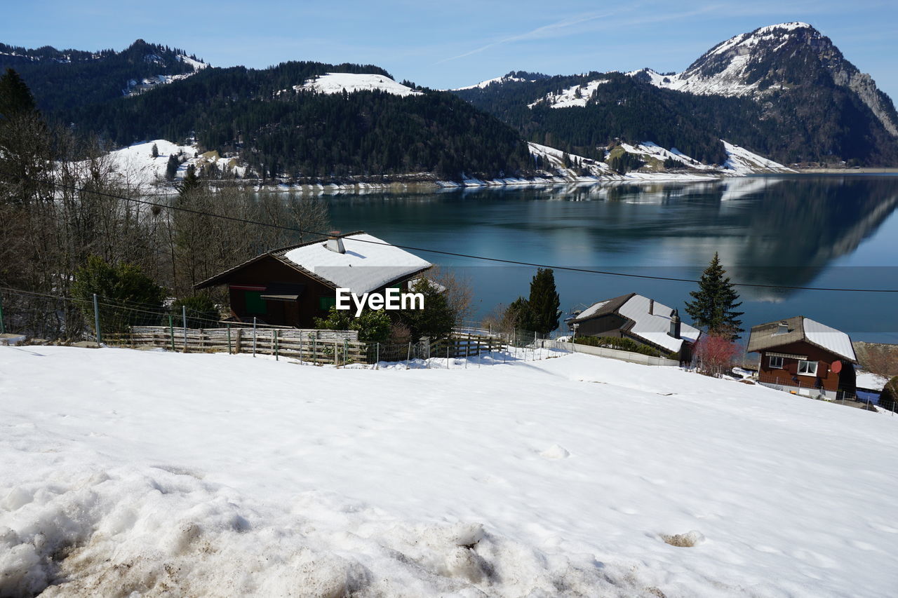 SCENIC VIEW OF SNOWCAPPED MOUNTAINS AND HOUSES AGAINST SKY