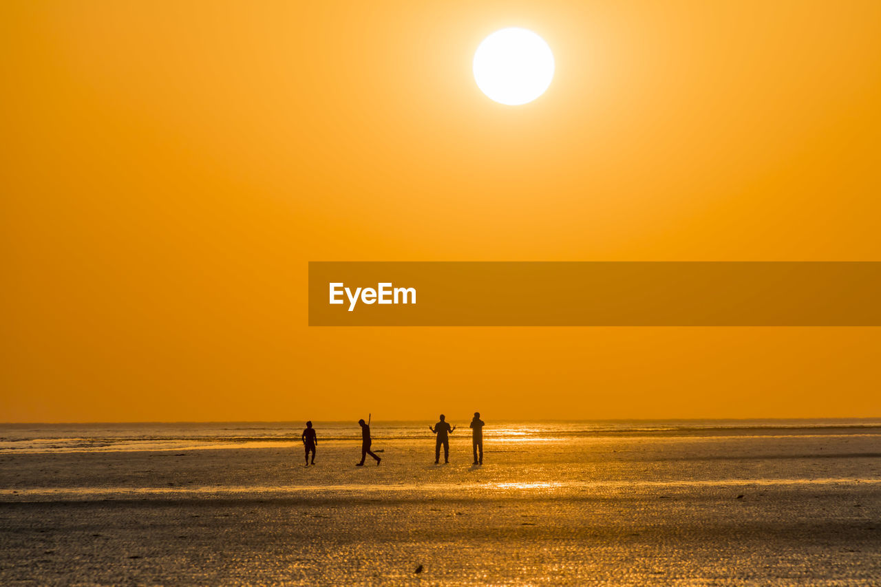 SILHOUETTE PEOPLE AT BEACH DURING SUNSET