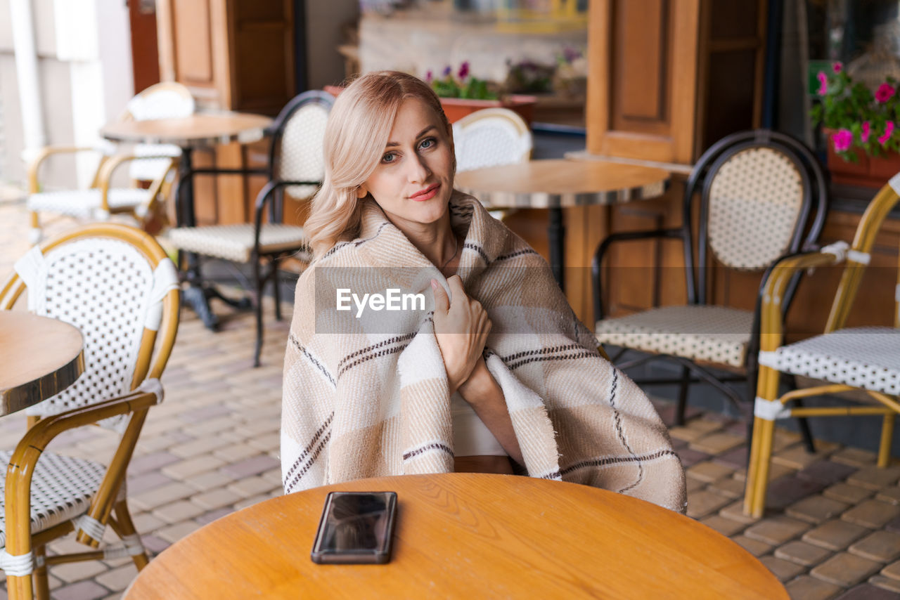 young woman sitting on chair at restaurant