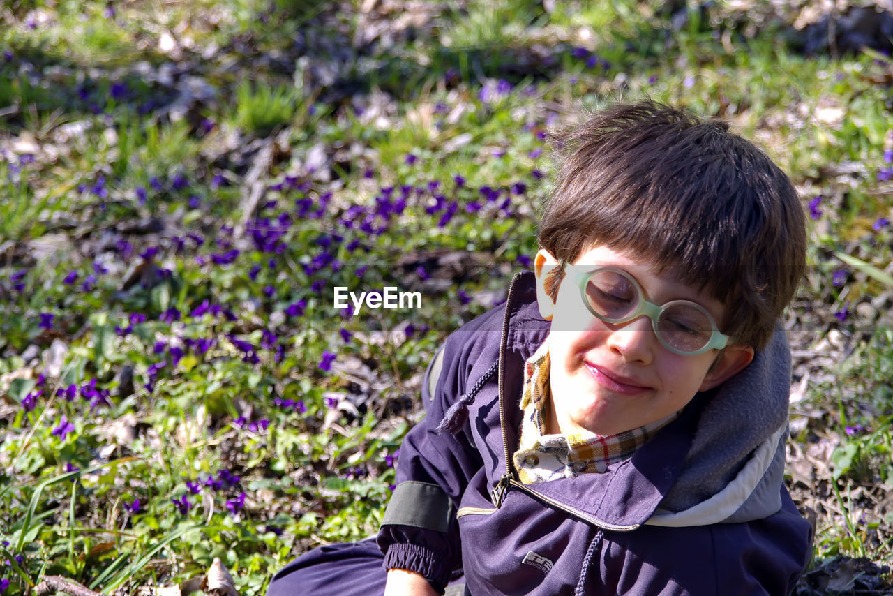 PORTRAIT OF A BOY WITH PURPLE FLOWER