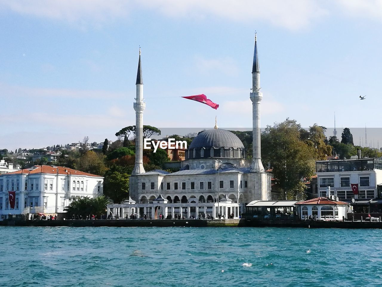 Mosque at waterfront against sky