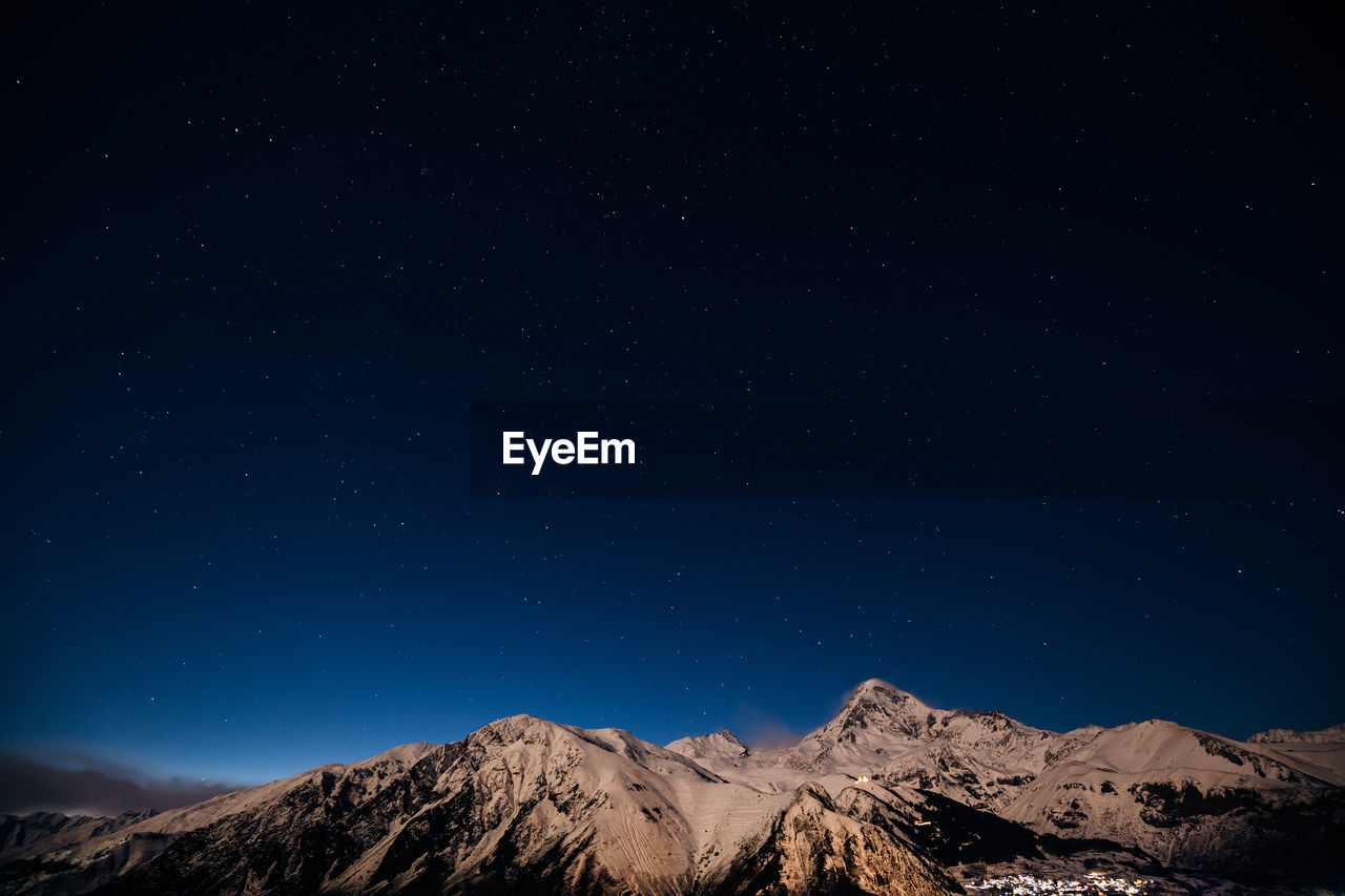 Low angle view of mountain against blue sky