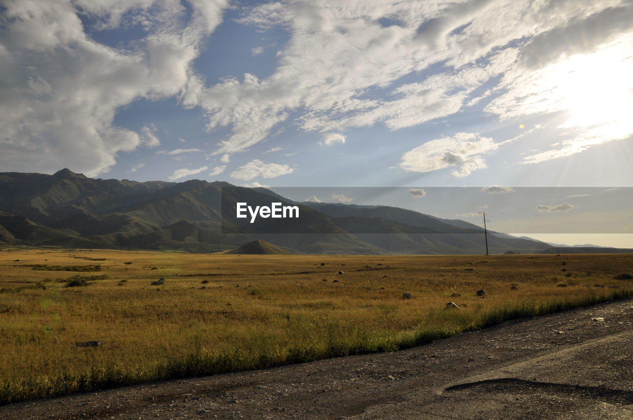 SCENIC VIEW OF ROAD BY MOUNTAINS AGAINST SKY