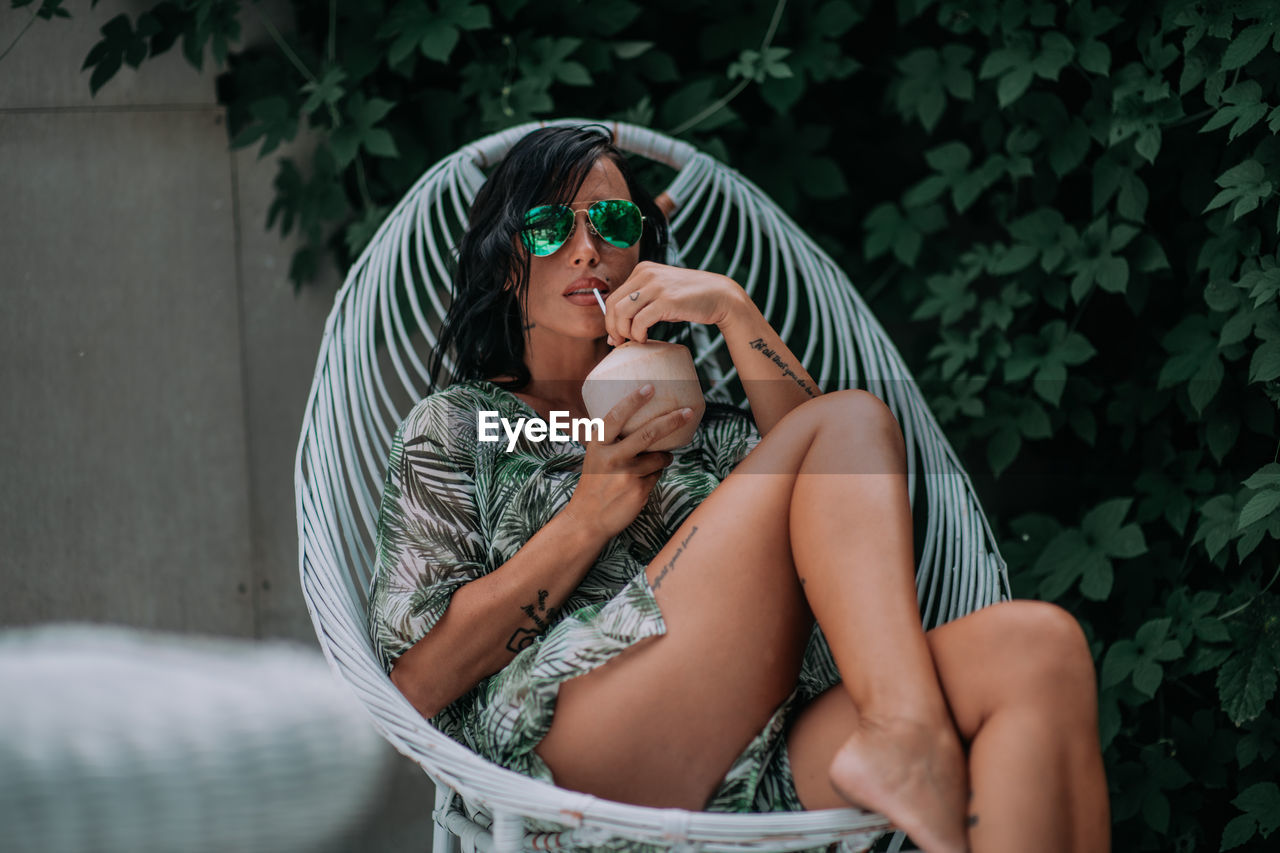 Midsection of woman holding while sitting in water