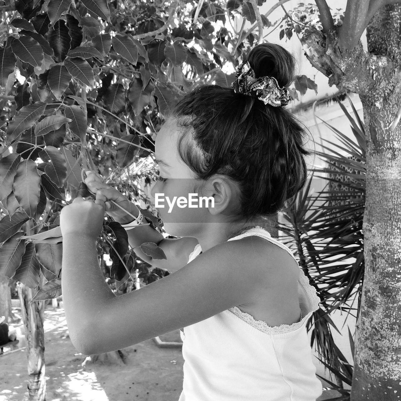 Side view of cute girl standing by plants