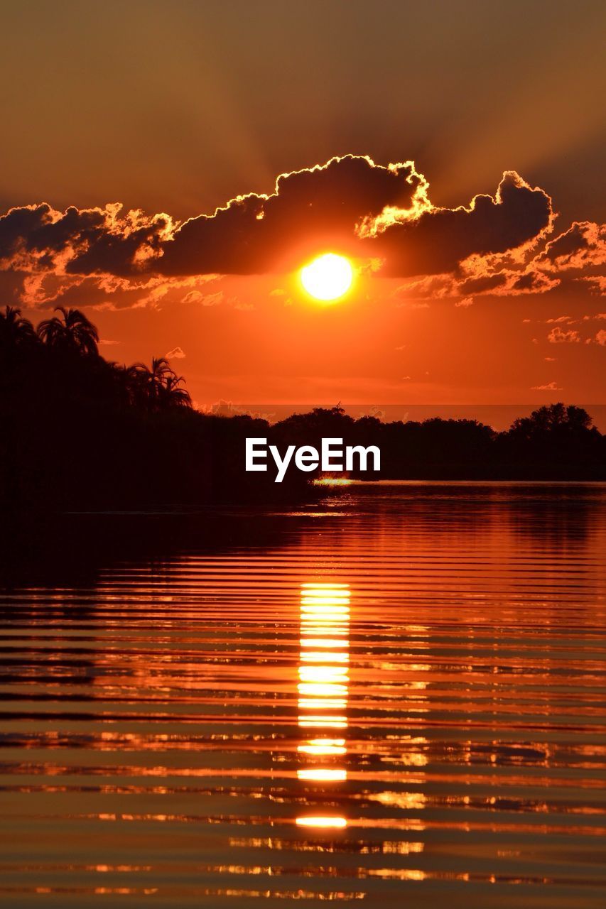 SCENIC VIEW OF LAKE AGAINST ORANGE SKY DURING SUNSET