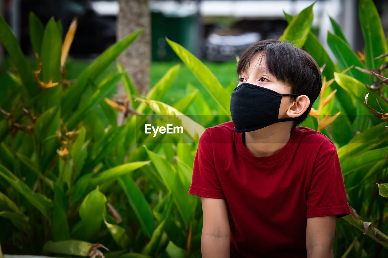 Young kid wearing protection mask. reusable black face mask. new normal social distancing.