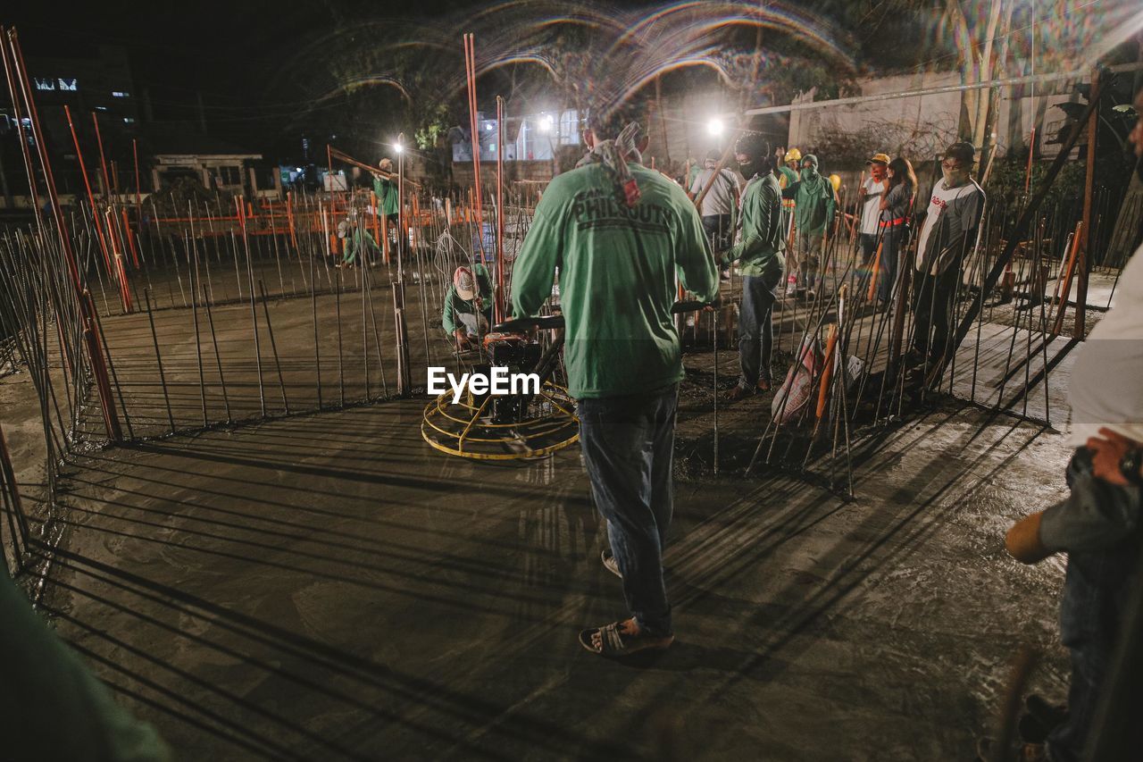 GROUP OF PEOPLE WORKING IN ILLUMINATED SHOPPING MALL