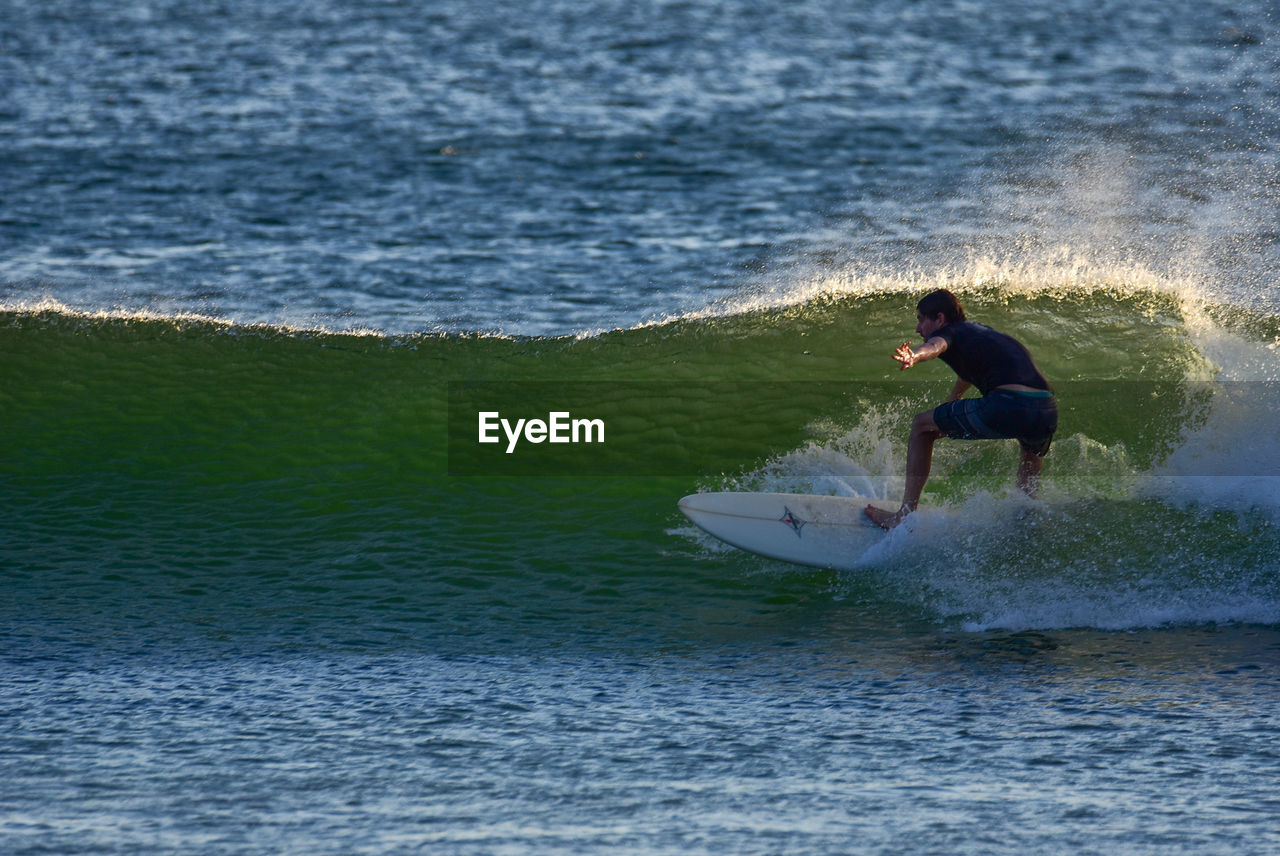 Rear view of man surfing in sea