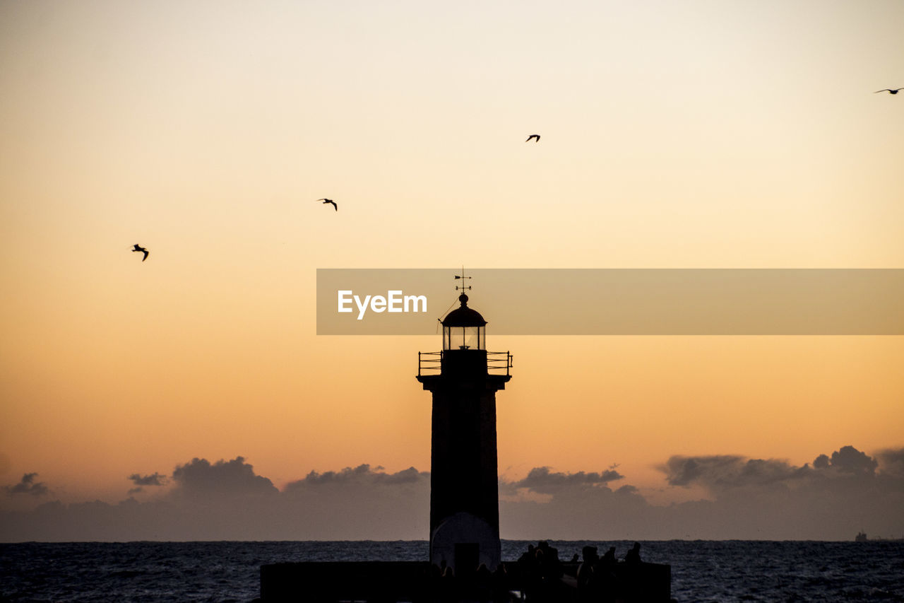 SILHOUETTE OF LIGHTHOUSE AT SUNSET